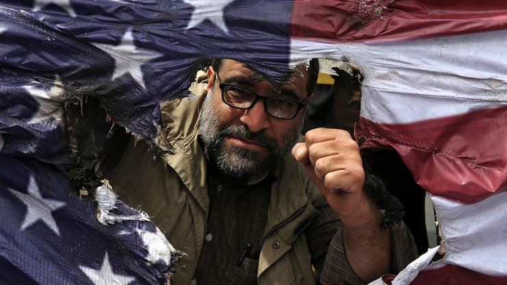 איראן טהרן שורפים דגלי ארה"ב ארצות הברית אחרי הפרישה מ הסכם הגרעין