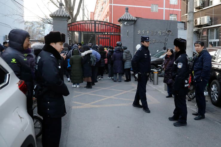 שוטרים והורים מחוץ ל בית ספר יסודי ב בייג'ינג בירת סין שבו תקף גבר תלמידים בפטיש