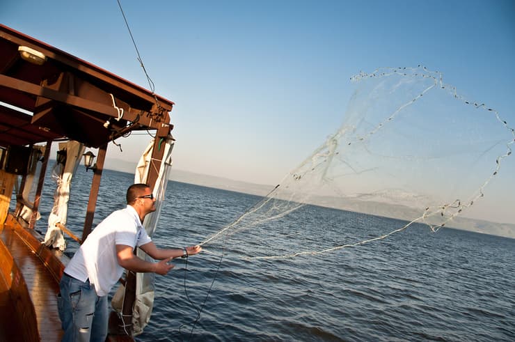 דייג משליך רשת דיג לכינרת