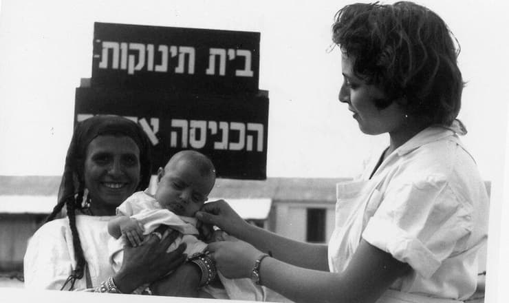 אחות לצד יוצאת תימן ובנה, בפתח בית תינוקות במחנה עין שמר