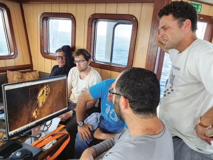 משמאל: פרופ' גרופר, שמואל כהן, קובי שרביט, בן הרצברג וד"ר דיאמנט צופים בתמונה שתיעד הרובוט בקרקעית הים