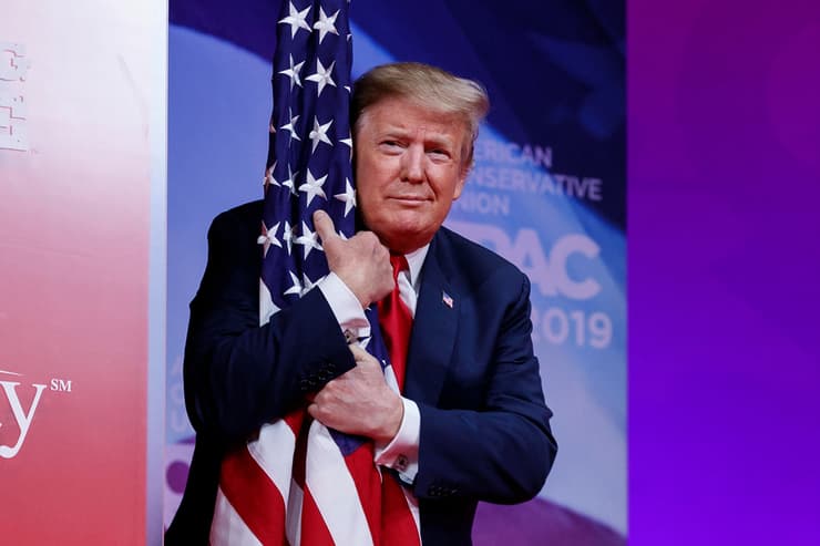 תמונות השנה AP דונלד טראמפ מחבק את דגל ארה"ב כנס CPAC  הכינוס לפעולה שמרנית פוליטית