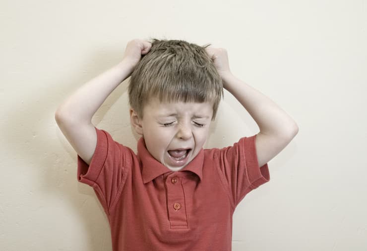 ילד צועק ומושך בשערות ראשו 