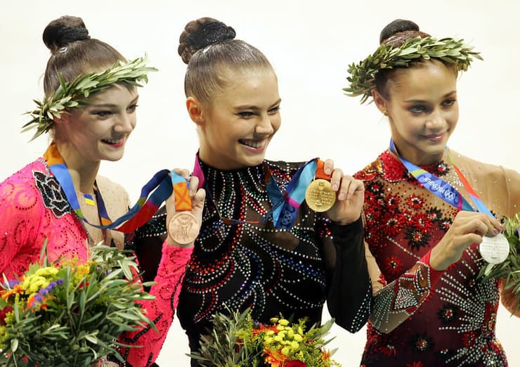 אלינה קבייבה (במרכז) עם מדליית הזהב האולימפית באתונה