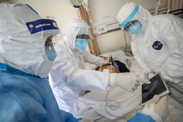 רופא בודק חולה שנדבק בנגיף הקורונה בבית חולים בווהאן