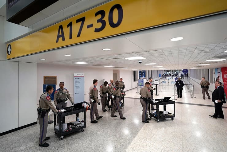 שוטרי מחלקת בריאות הציבור טקסס מחכים לנוסעים שצריכים בידוד ב נמל תעופה ארה"ב נגיף קורונה