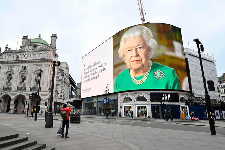 שלט חוצות של המלכה אליזבת כיכר פיקדילי לונדון נגיף קורונה בריטניה