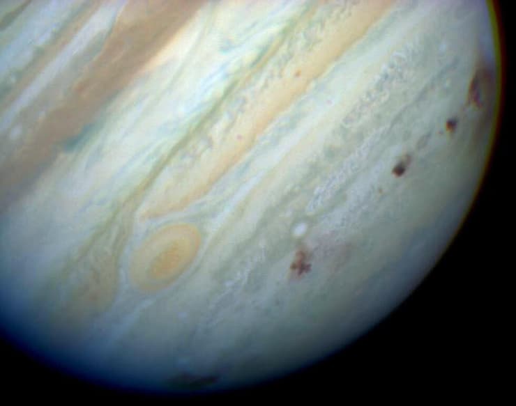 כתמים חומים מסמנים את שביט שומייקר-לוי 9, שהתנגש בצדק והשאיר צלקות למשך כשנה על חצי הכדור הדרומי שלו ב-1994. צילום - טלסקופ החלל האבל