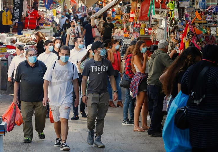 אנשים ב שוק הכרמל תל אביב קונים עם מסכות נגיף קורונה