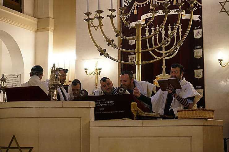 הרב מיכאל אזולאי, שני מימין, קורא בתורה עם אנשי הקהילה בבית הכנסת בניי-סור-סן, פרבר של פריז, ב-11 בדצמבר 2017