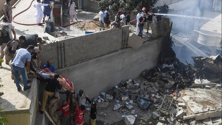 עובדי הצלה מעבירים גופה מהתרסקות המטוס בפקיסטן
