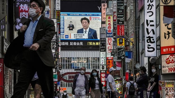 שינזו אבה ראש ממשלת יפן על מסך ב טוקיו