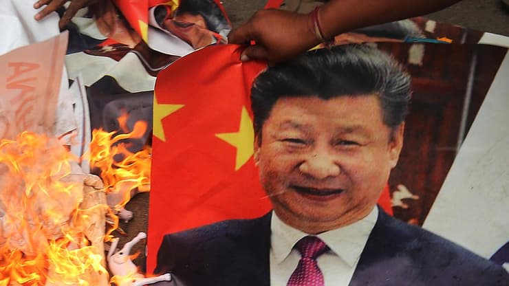 הודו מפגינים דורכים על תמונת נשיא סין שי ג'ינפינג ושורפים אותה