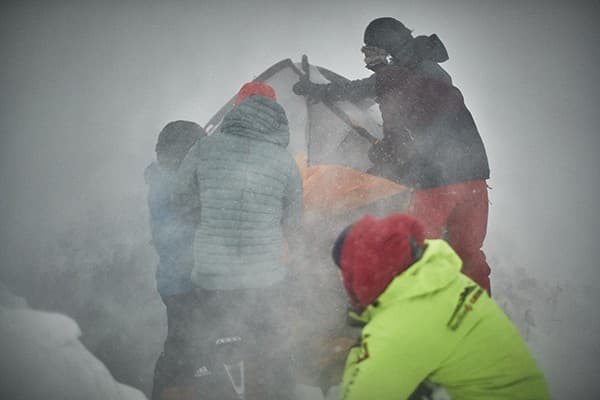 צוות הצילום מקים את האוהל על פסגת ההר    