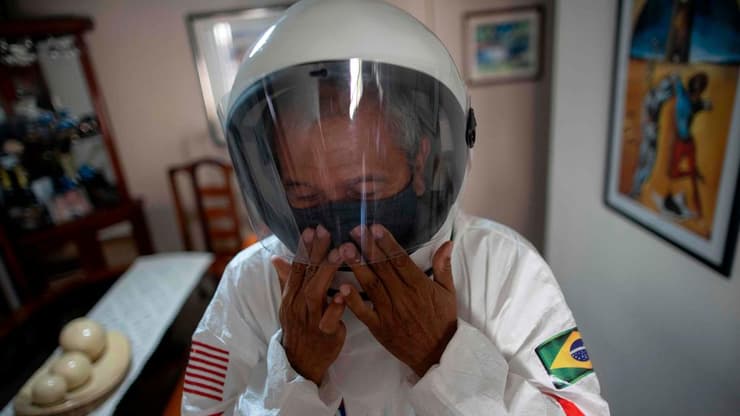 ברזיל ריו דה ז'ניירו זוג יוצא מהבית עם חליפות אסטרונאוטים נגד ה קורונה
