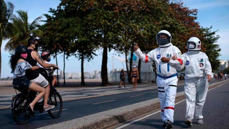 ברזיל ריו דה ז'ניירו זוג יוצא מהבית עם חליפות אסטרונאוטים נגד ה קורונה