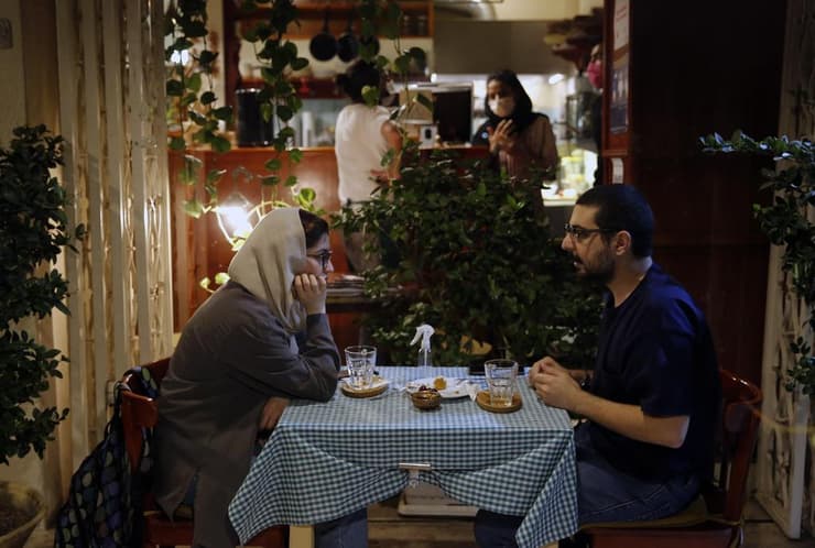 האיראנים לא יכולים להרשות לעצמם סגר נוסף. זוג בבית קפה בטהרן