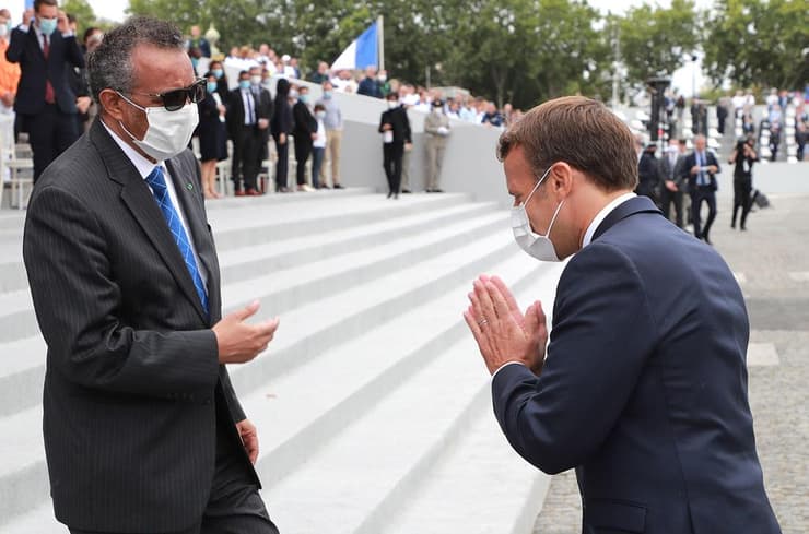 נשיא צרפת עמנואל מקרון עם מזכ"ל ארגון הבריאות העולמי טדרוס אדהנום ב חגיגות יום הבסטיליה ב פריז