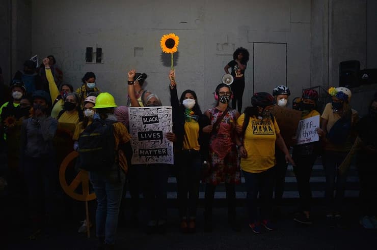 ארה"ב מחאת ג'ורג' פלויד פורטלנד אימהות בצהוב מפרידות בין מפגינים ל כוחות הביטחון