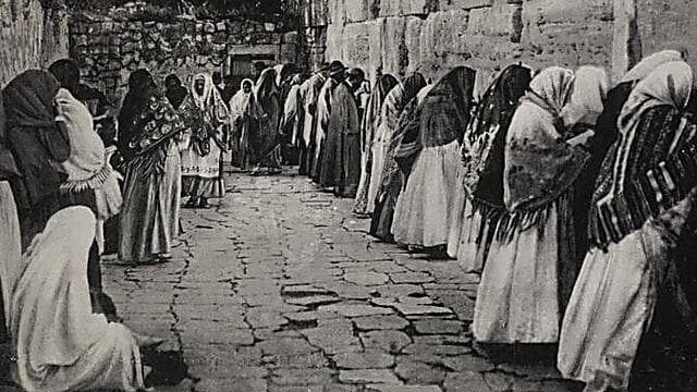 נשים יהודיות עטויות שביסים מתפללות לפני הכותל המערבי