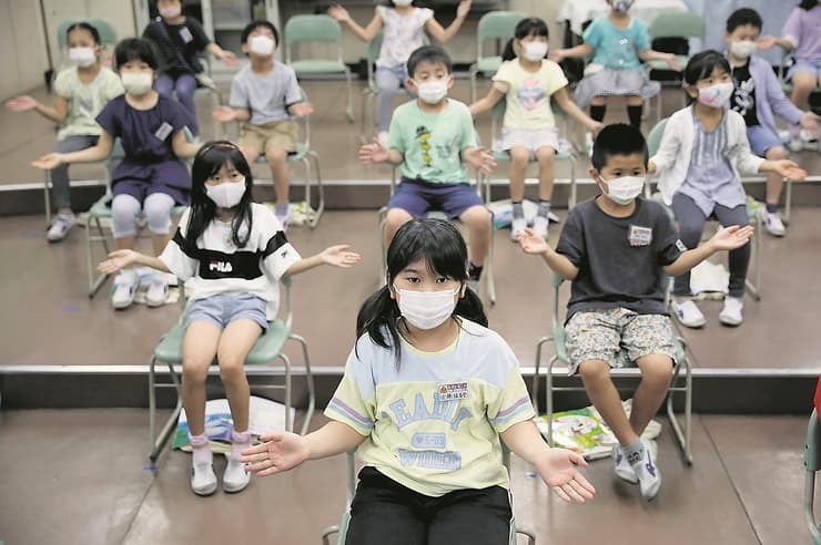 ילדים יושבים בכיתה עם מסכה