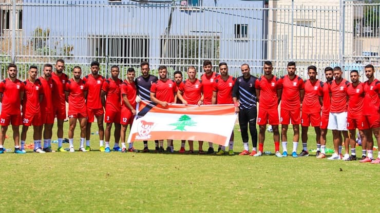 שחקני בני סכנין עם דגל לבנון ועליו סמל המועדון