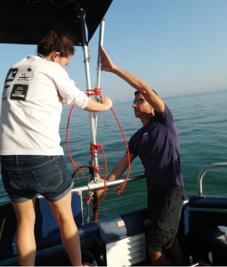 מייקל לזר ונעמה שריד (אוניברסיטת חיפה) מתקינים את מכשיר הסונאר על גבי הסירה בכינרת 