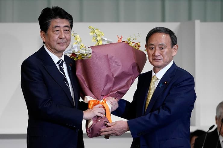 יפן ראש הממשלה היוצא שינזו אבה פרחים ל מחליפו הנבחר יושיהידה סוגה