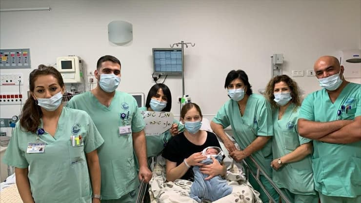 יפעת ניילינגר עם בנה ואנשי צוות חדר הלידה