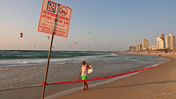  אנשים מבלים בחוף הים בתל אביב