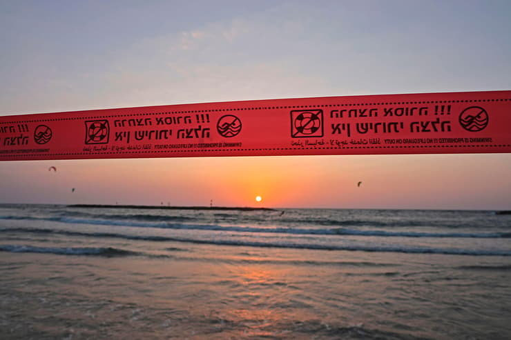  אנשים מבלים בחוף הים בתל אביב