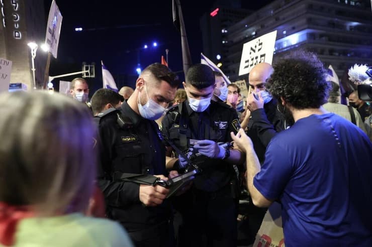 שוטרים מחלקים דוחות בהפגנה