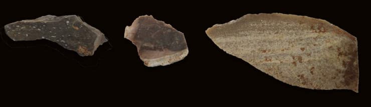 שלושה פריטים ארכיאולוגיים, שלוש דרגות חום שונות (מימין, לא בקנה מידה): להב, נתזים מסותתים ורסיסי צור שניתזו באופן ספונטני.