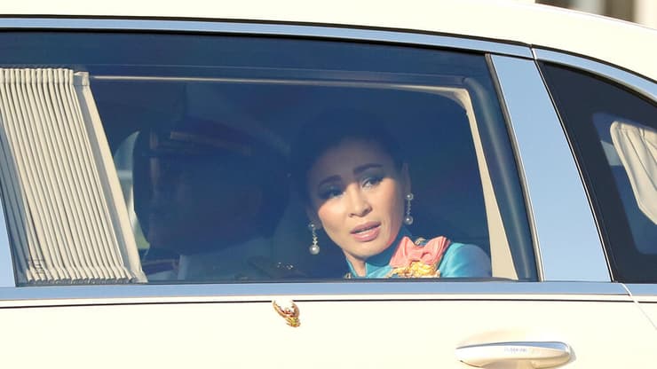 מלכת תאילנד והמלך בשיירה מול המפגינים 