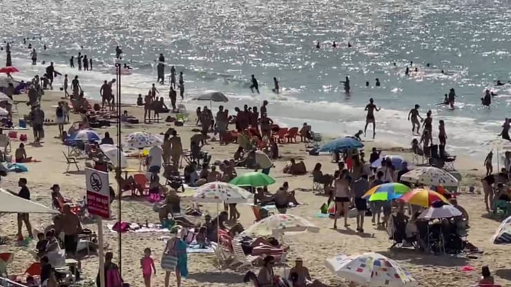 הרבה רוחצים בחוף הים בתל אביב