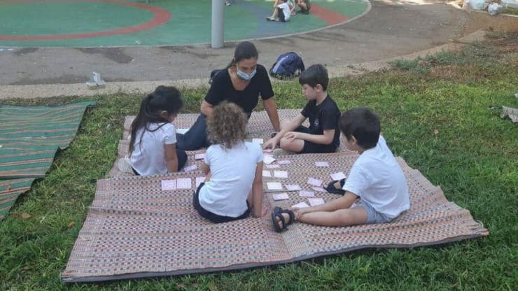 ילדים לומדים בגינה הסמוכה לבית הספר ברעננה