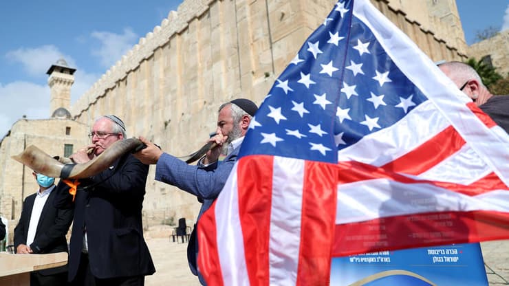 Israeli settlers blow the Shofar, a ceremonial ram's horn, as they gather to show their support for U.S. President Donald Trump in the upcoming U.S. election,