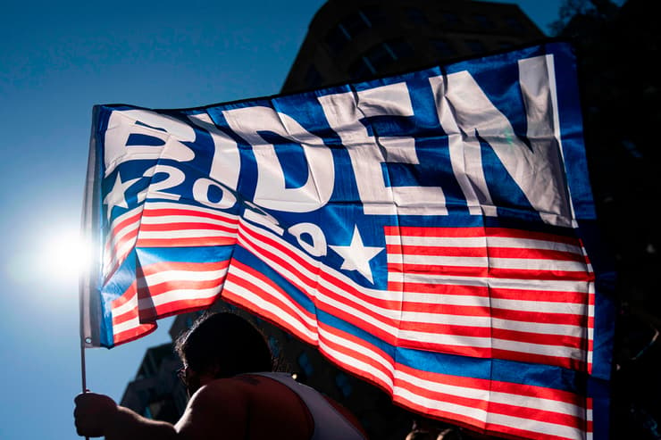 תומך של ג'ו ביידן מניף דגל מול הבית הלבן בוושינגטון