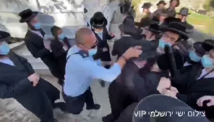 קצין משטרה בעט במפגינים חרדים במהלך הפגנה אשר מחו על הרחבה של מלון במקום של קברי יהודים