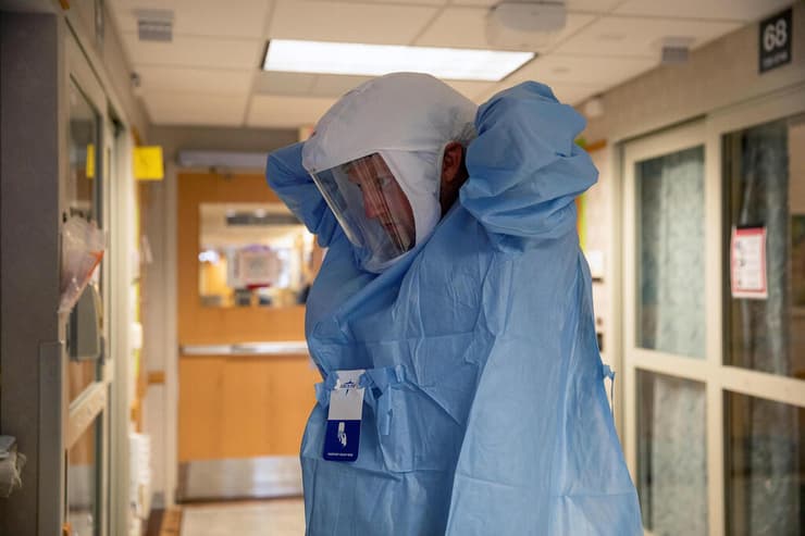 ארה"ב נגיף קורונה אח לובש ציוד מגן לקראת ביקור אצל חולי קורונה בית חולים וויסקונסין