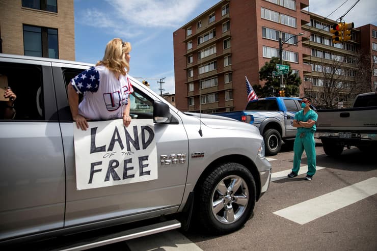 תמונות השנה בעולם של רויטרס עובד צוות בריאות חוסם דרכם של מפגינים נגד הגבלות הקורונה קולורדו ארה"ב