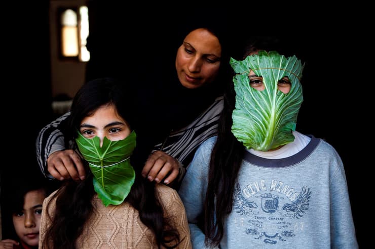 תמונות השנה בעולם של AFP בית להייה רצועת עזה אמא הכינה לילדיה מסכות מ כרוב