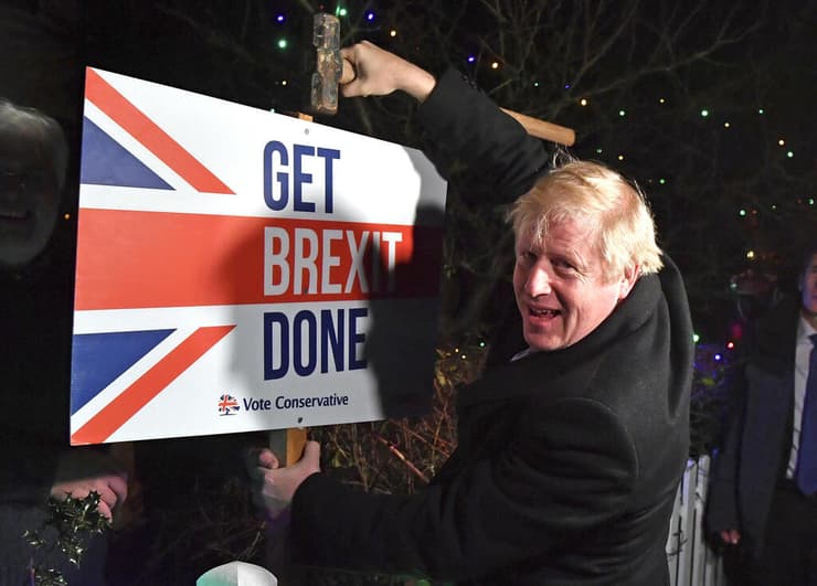 ראש ממשלת בריטניה בוריס ג'ונסון עם שלט תמיכה ב ברקזיט דצמבר 2019