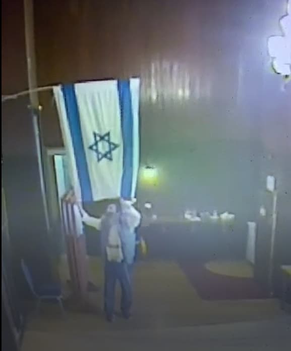 המתפלל מוריד את הדגל בבית הכנסת