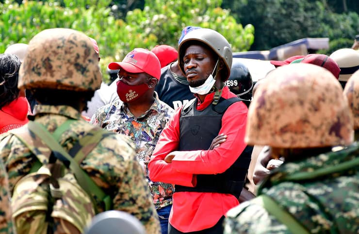 אוגנדה כוכב פופ בובי וויין מועמד ל נשיאות עם שוטרים אחרי מעצרו ב דצמבר
