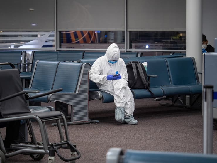 נוסע עם חליפת מגן לפני עלייה למטוס נמל התעופה הבינלאומי שיקגו או'הייר ארה"ב