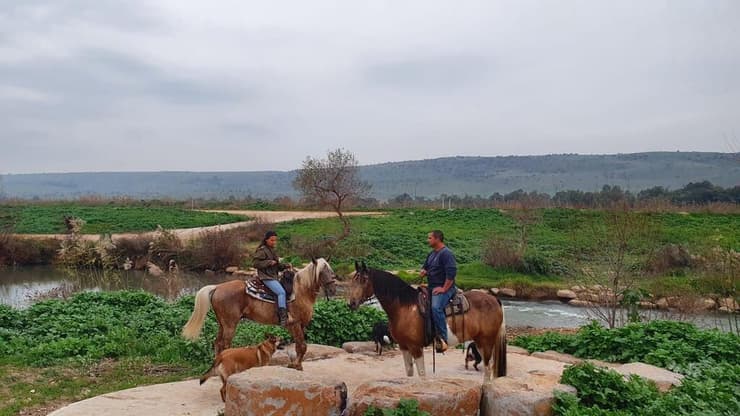 תושבי האזור רוכבים על סוסים סמוך לחלק מהתעלה שכבר שוקם, השבוע