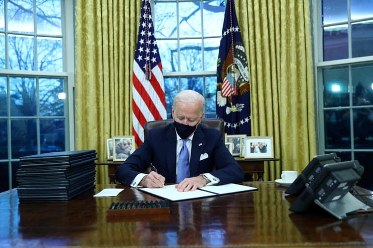 נשיא ארה"ב ג'ו ביידן ב הבית הלבן החדר הסגלגל חותם על צו נשיאותי צווים
