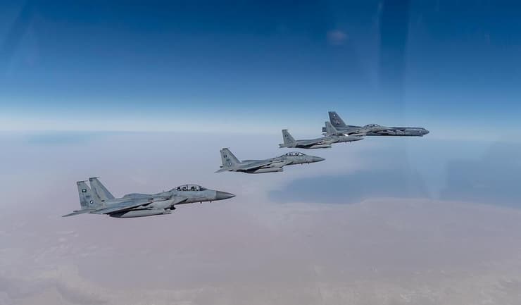 מטוס מטוסי קרב סעודיים של סעודיה מסוג F-15 SA לצד מפציץ אמריקני מסוג B-52 