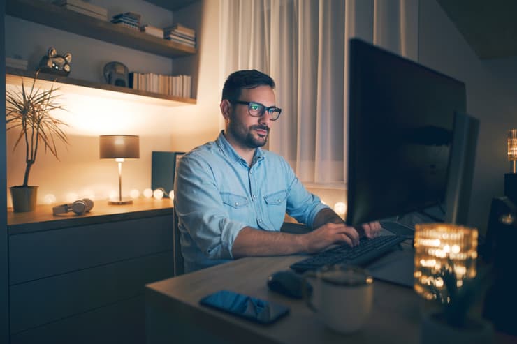 גבר עובד במחשב אל תוך הלילה במקום ללכת לישון